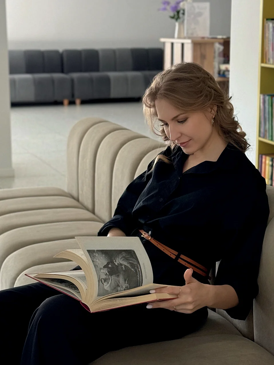Девушка читает книгу в библиотеке